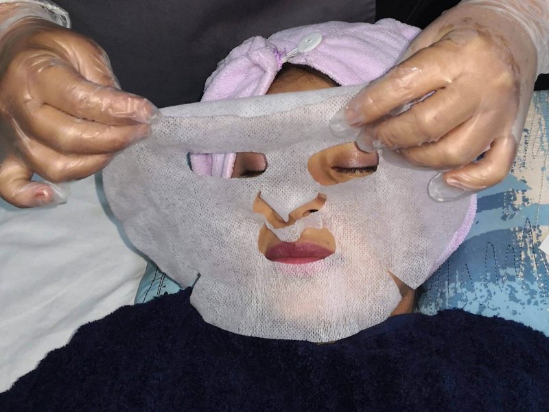 Mujer recibiendo tratamiento de limpeza facial en su rostro